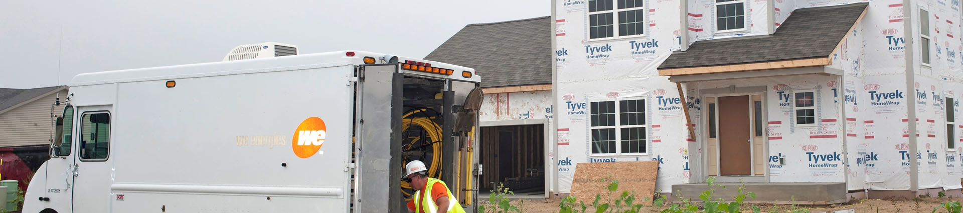 we energies employee and truck working at a new home construction site